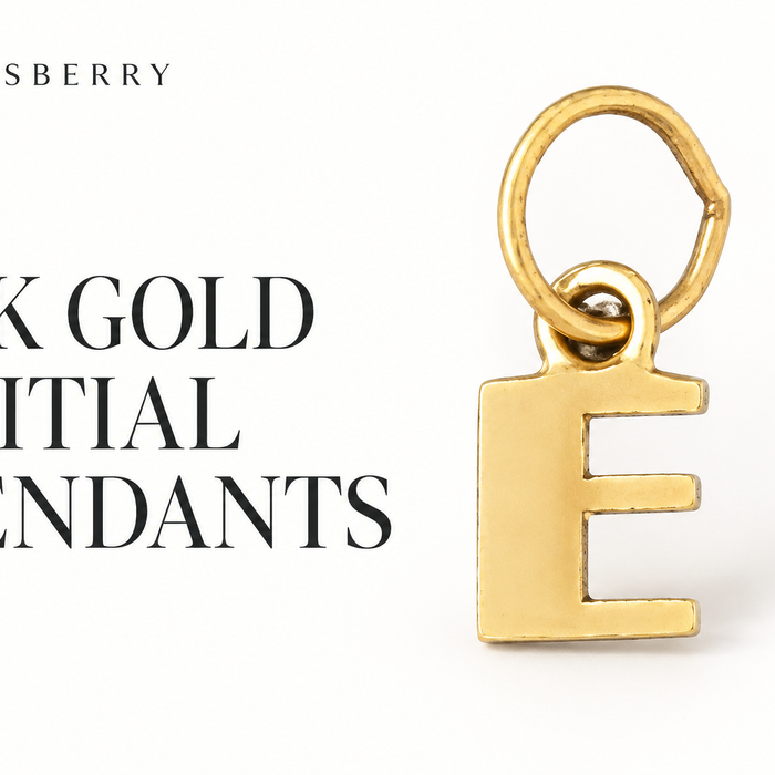 Yellow gold capital E initial pendant with an oval attachment loop on a white background